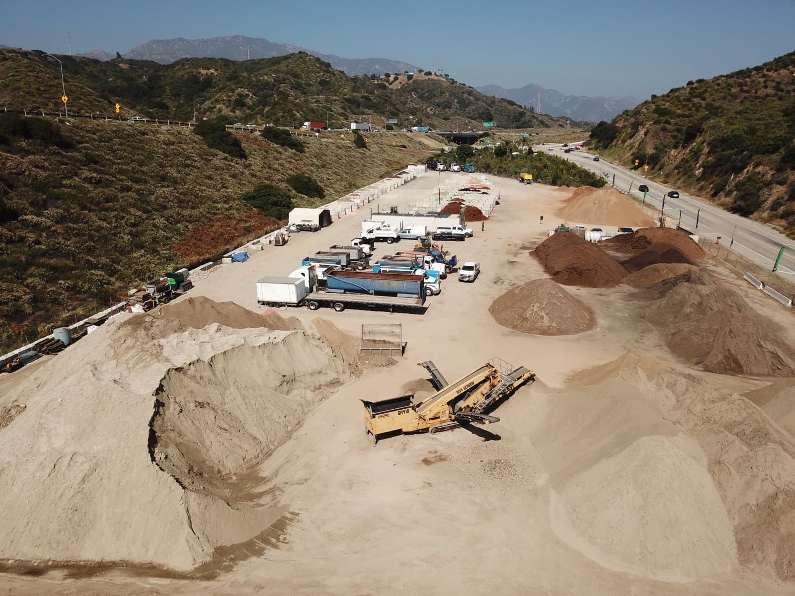 Aerial view of the Soil Direct yard with bulk soil, mulch, and aggregate stockpiles